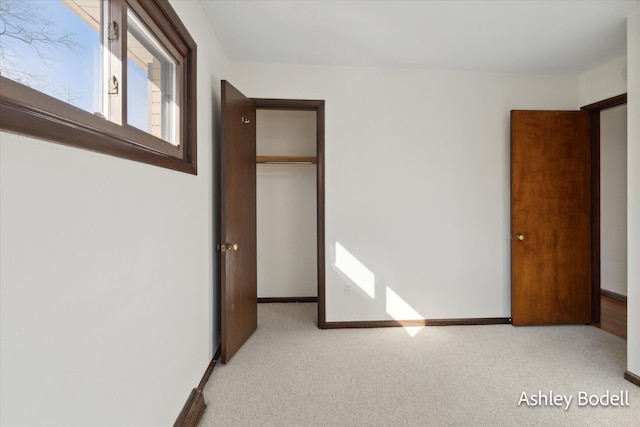 unfurnished bedroom with carpet floors, a closet, and baseboards