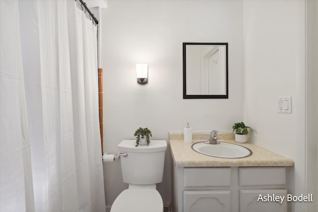 bathroom with curtained shower, vanity, and toilet