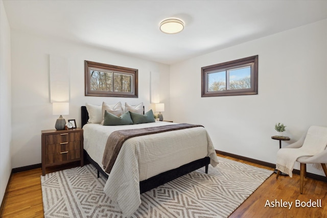 bedroom featuring light wood finished floors and baseboards