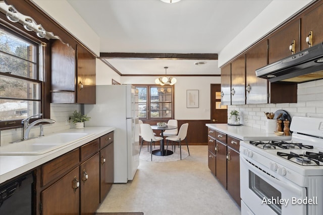 kitchen featuring light countertops, white appliances, a sink, and under cabinet range hood