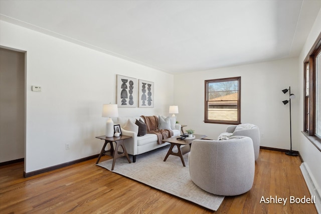 living area with baseboards and wood finished floors