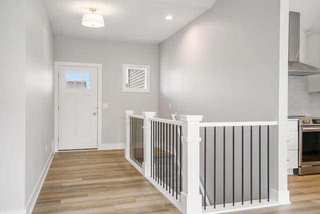 foyer entrance with light wood finished floors, recessed lighting, and baseboards