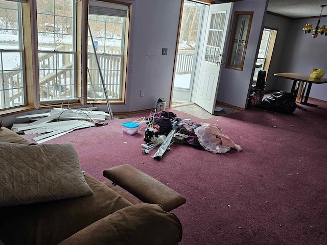 interior space with an inviting chandelier, baseboards, and carpet flooring