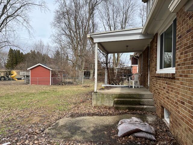 view of yard with covered porch and fence