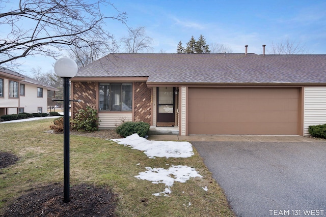 view of front facade featuring aphalt driveway, an attached garage, brick siding, roof with shingles, and a front lawn