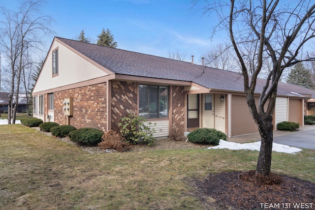 view of front of house featuring a garage, a front yard, brick siding, and a shingled roof