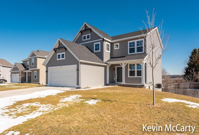 view of front of home with roof with shingles, concrete driveway, a front yard, central AC, and a garage