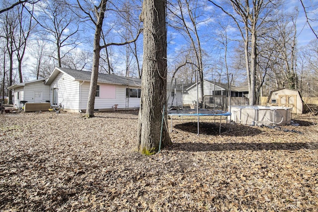 view of yard with an outbuilding, an outdoor pool, and a storage shed