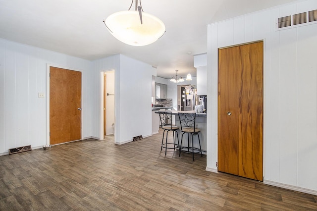 interior space featuring wood finished floors, visible vents, and a notable chandelier