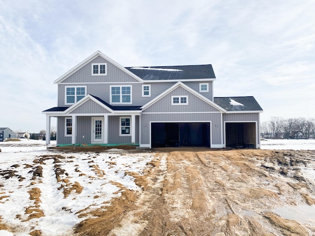 view of front of property featuring a garage, covered porch, and a shingled roof