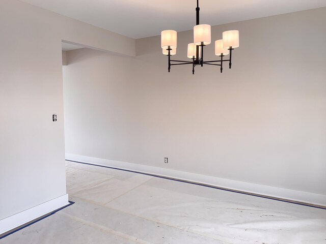 10712 Melanie Dr, Allendale, MI 49401 - unfurnished dining area featuring baseboards, concrete flooring, and a notable chandelier