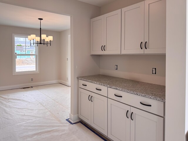10712 Melanie Dr, Allendale, MI 49401 - kitchen featuring an inviting chandelier, visible vents, baseboards, white cabinets, and decorative light fixtures