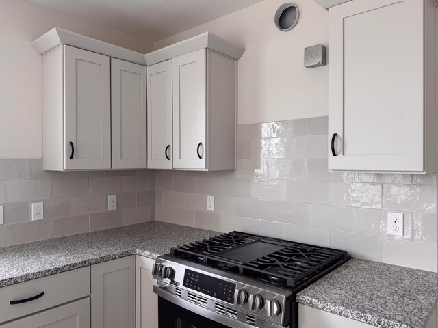 10712 Melanie Dr, Allendale, MI 49401 - kitchen featuring decorative backsplash, white cabinetry, and stainless steel gas range oven