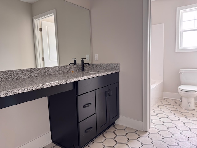 10712 Melanie Dr, Allendale, MI 49401 - full bath with tile patterned flooring, vanity, toilet, baseboards, and a bath