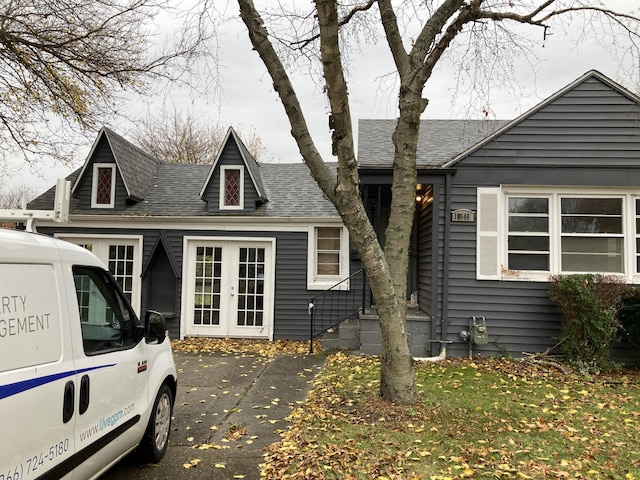 view of front facade with french doors and roof with shingles