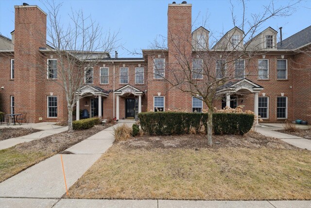 view of front of property with brick siding and a chimney