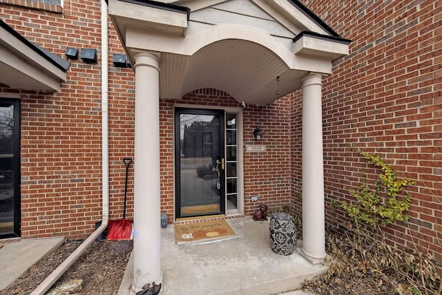 entrance to property featuring brick siding