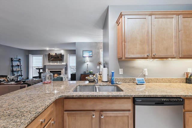 kitchen featuring open floor plan, dishwasher, a sink, and light brown cabinetry