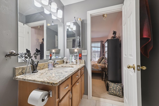 ensuite bathroom with ensuite bath, tile patterned flooring, and vanity