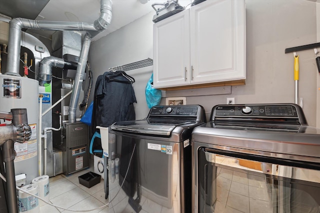 clothes washing area with light tile patterned flooring, cabinet space, washer and clothes dryer, and water heater