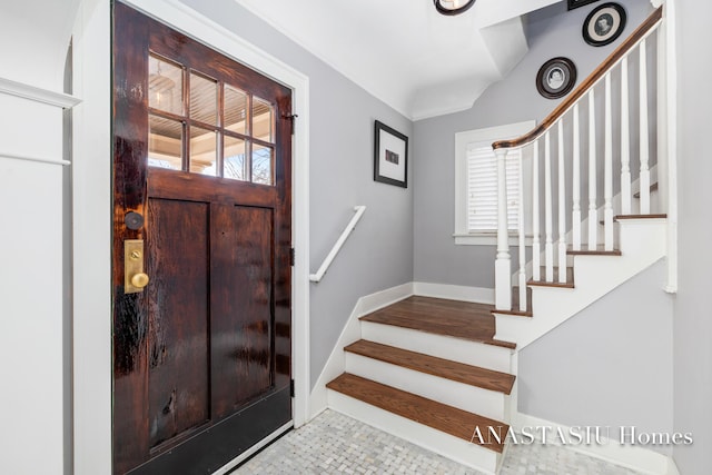 foyer with stairway, baseboards, and a wealth of natural light