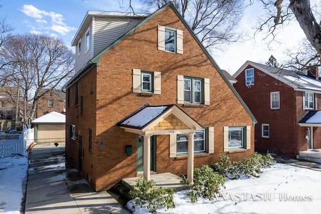 view of front of home with brick siding and fence