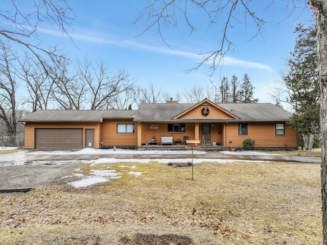 view of front of property with a garage, driveway, a porch, and a chimney