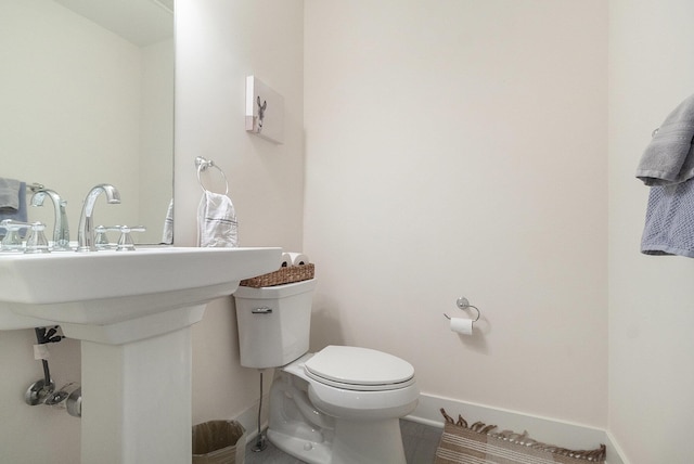 bathroom with toilet and baseboards