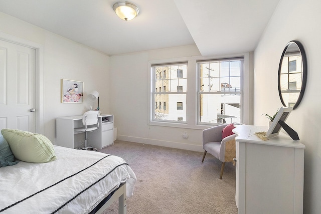 bedroom with light carpet and baseboards