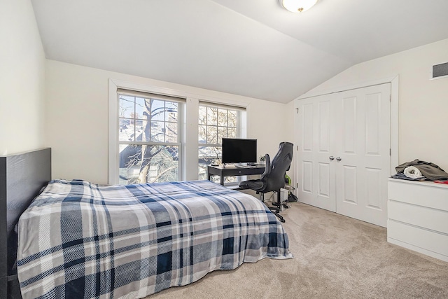 carpeted bedroom featuring lofted ceiling, a closet, and visible vents