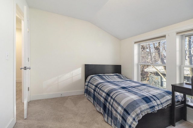 carpeted bedroom featuring lofted ceiling and baseboards