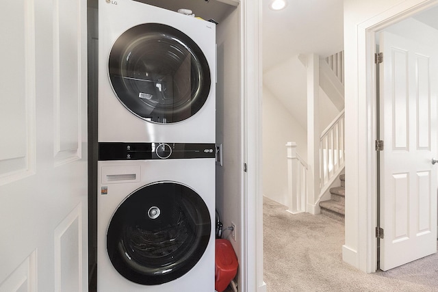 washroom with carpet floors, laundry area, and stacked washer / dryer