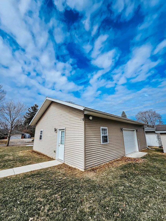 rear view of property with a garage and a yard