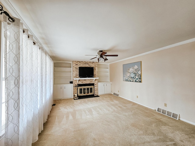 unfurnished living room with light carpet, a fireplace, visible vents, and ornamental molding