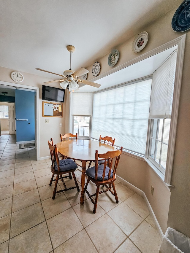 dining room with light tile patterned flooring, ceiling fan, and baseboards