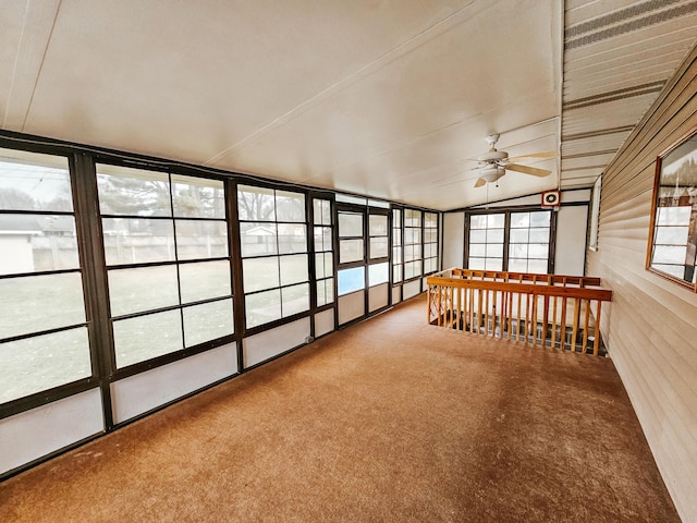 unfurnished sunroom with vaulted ceiling and a ceiling fan