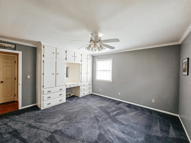 unfurnished bedroom featuring baseboards, dark colored carpet, and crown molding