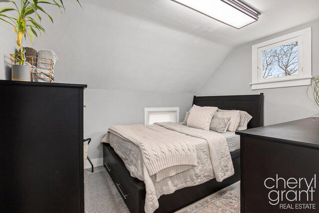 bedroom featuring vaulted ceiling and carpet