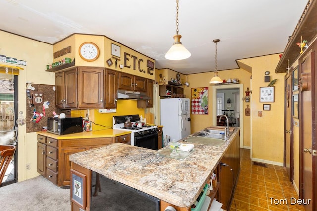 kitchen with stainless steel microwave, freestanding refrigerator, gas range oven, light countertops, and a sink