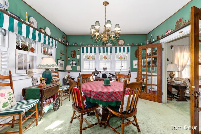 dining space featuring a healthy amount of sunlight, carpet flooring, and a notable chandelier