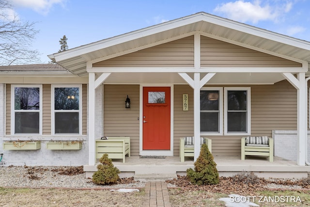 view of front of home with a porch and brick siding