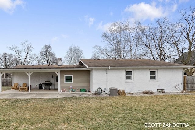 back of house featuring brick siding, central air condition unit, a lawn, a patio area, and fence