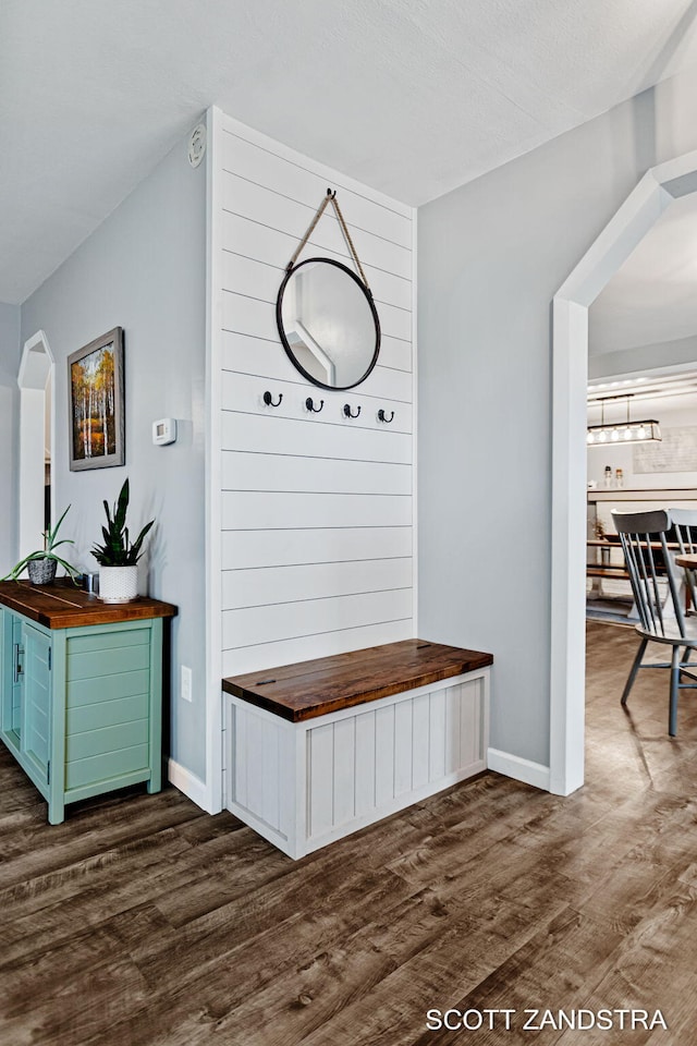 mudroom featuring dark wood-style flooring and baseboards