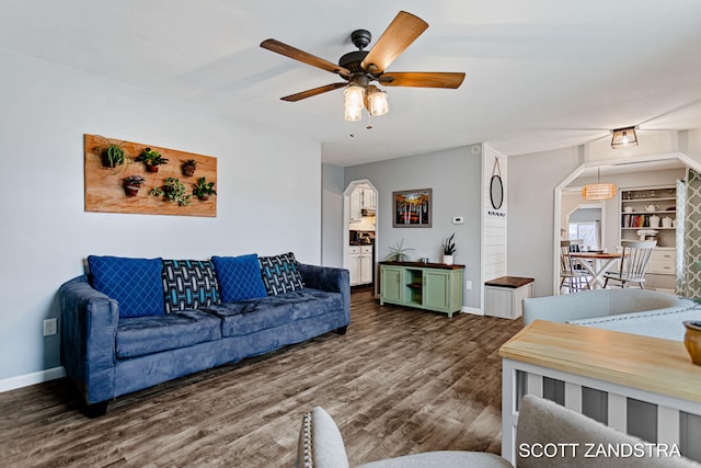 living room featuring ceiling fan, baseboards, and wood finished floors