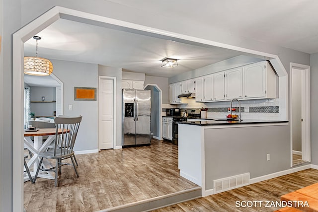 kitchen featuring visible vents, dark countertops, stainless steel appliances, white cabinetry, and a sink