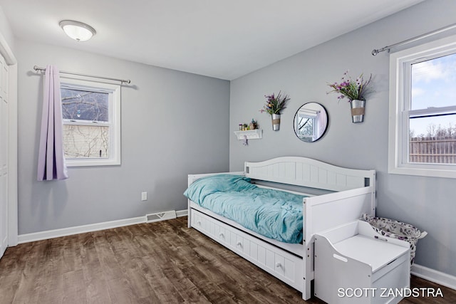 bedroom with visible vents, baseboards, and dark wood finished floors