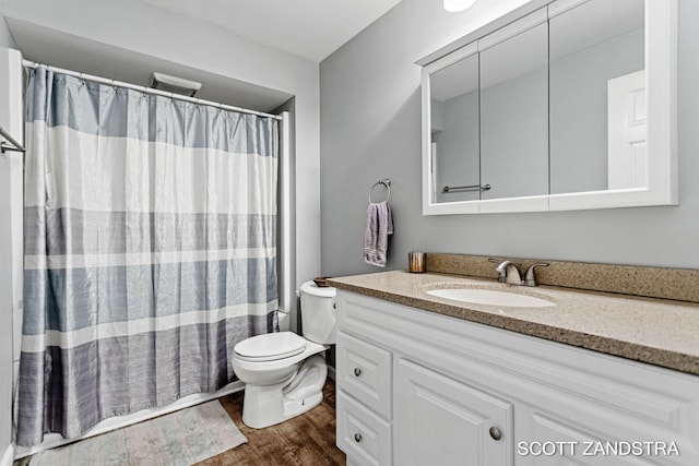 bathroom with toilet, curtained shower, wood finished floors, and vanity