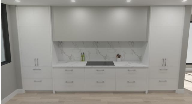 kitchen featuring tasteful backsplash, light stone counters, and modern cabinets