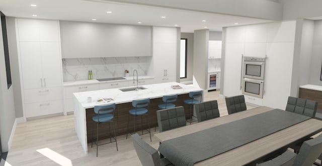 kitchen featuring a kitchen island with sink, modern cabinets, a sink, and white cabinetry