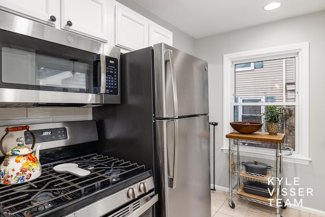 kitchen featuring baseboards, appliances with stainless steel finishes, light tile patterned flooring, white cabinetry, and recessed lighting